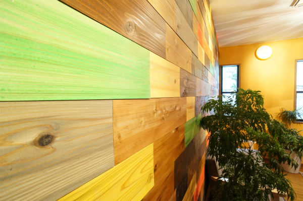 壁に貼られている木の板は、1枚1枚色が異なっています。